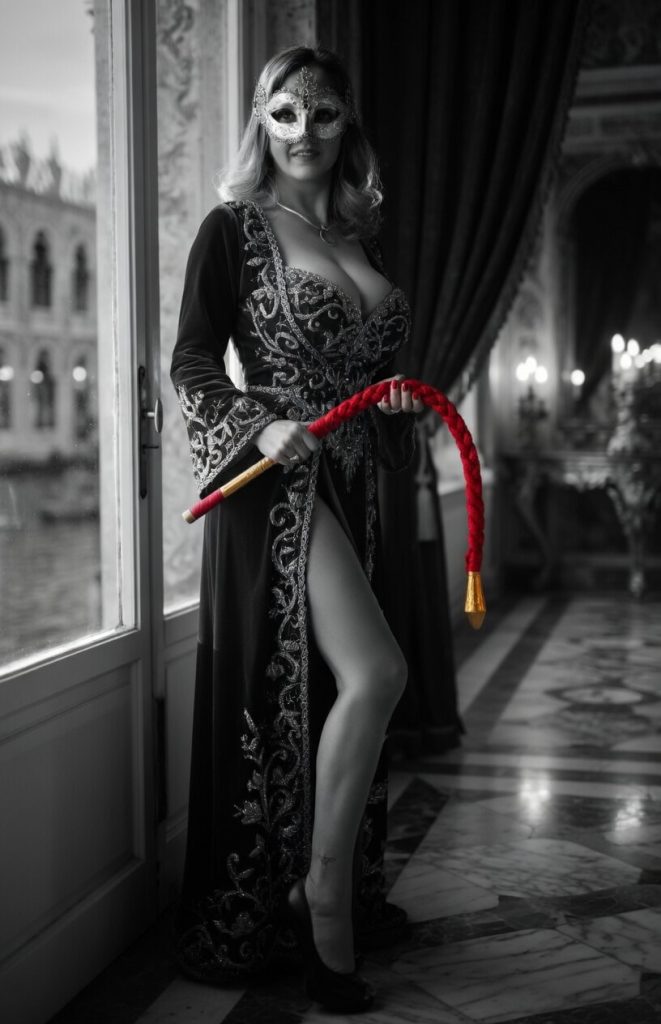 Valeria masked holding red whip in palace corridor
